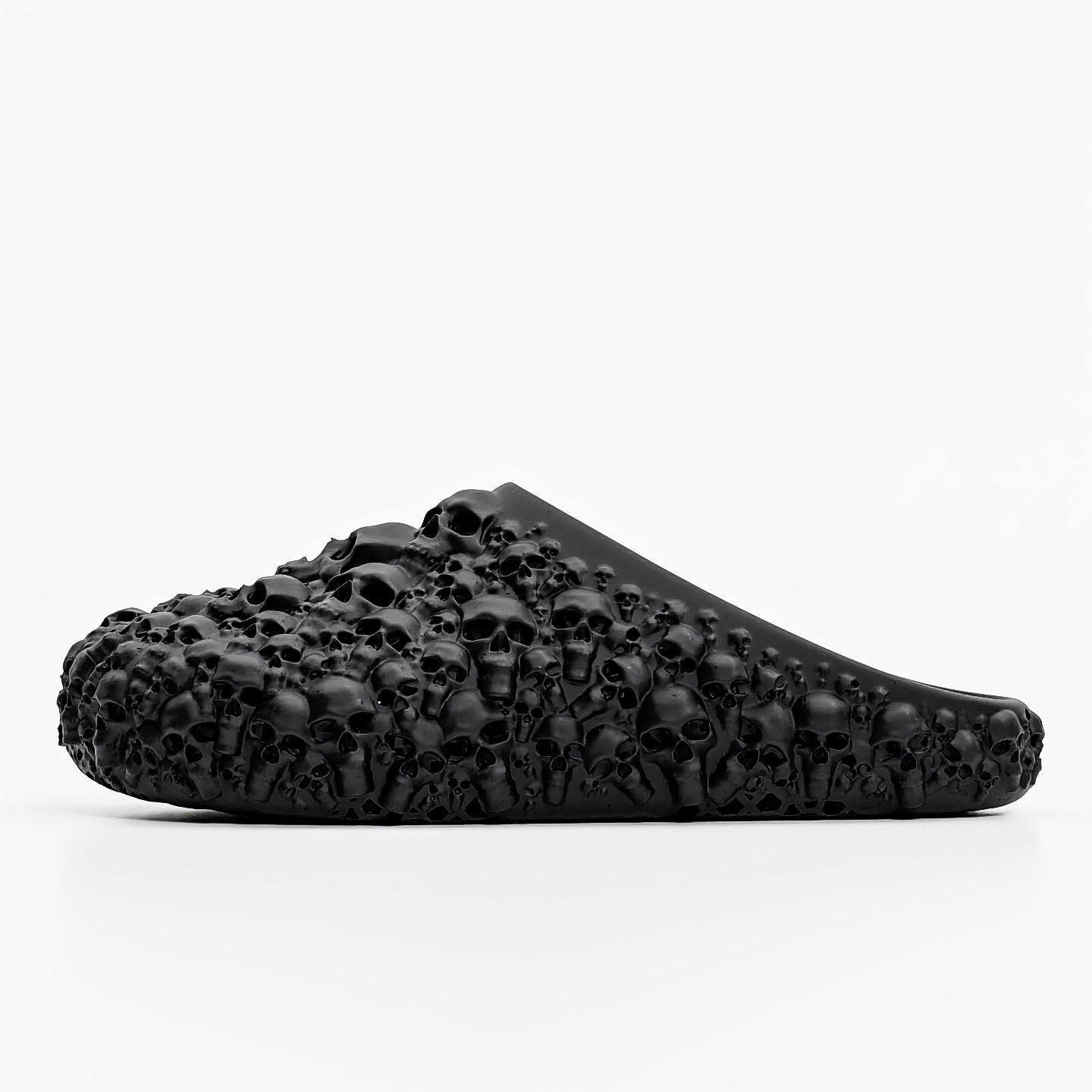 Black 3D printed mule covered in sculpted skulls, side view on white.